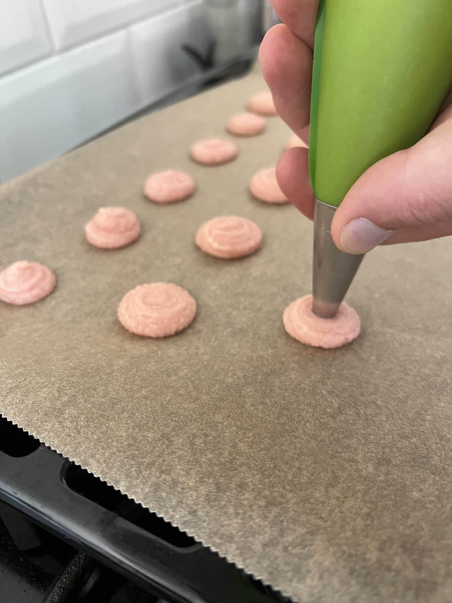 Using the piping bag to put macarons on the oven tray